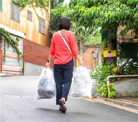 ▲ 용산구민이 쓰레기를 종량제 봉투에 담아 버리러 가는 모습.